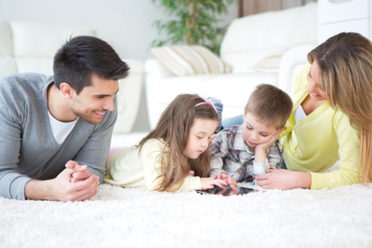 family-of-four-lying-on-white-carpet-best-critical-illness-insurance-quotes-canada