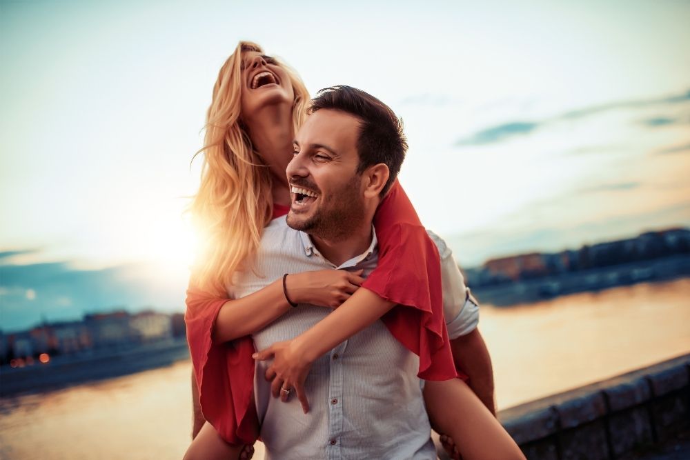 man-carrying-woman-laughing-by-lake-quotations-for-critical-illness-insurance